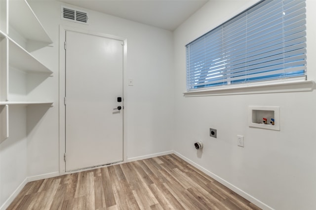 clothes washing area with light hardwood / wood-style floors, hookup for an electric dryer, and hookup for a washing machine