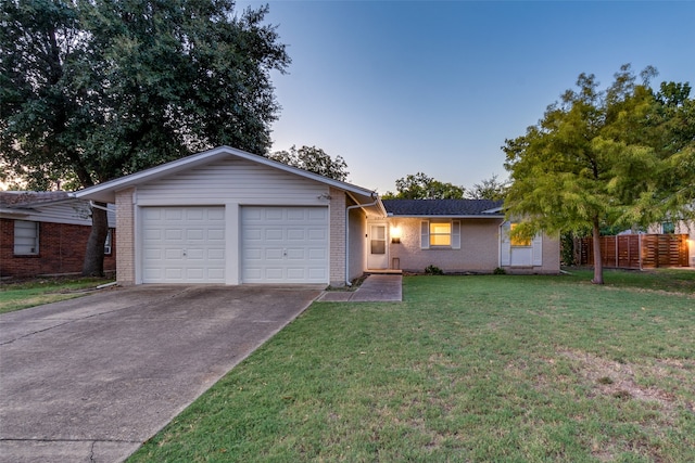 ranch-style home with a garage and a yard