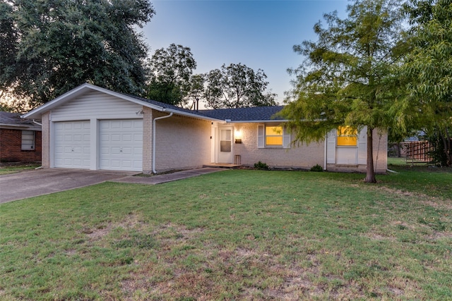 single story home featuring a garage and a lawn