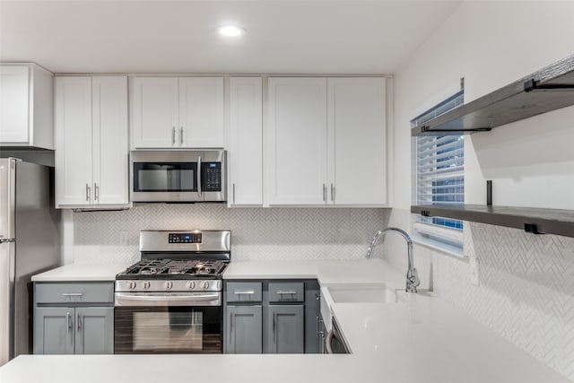 kitchen featuring appliances with stainless steel finishes, gray cabinets, white cabinetry, and sink