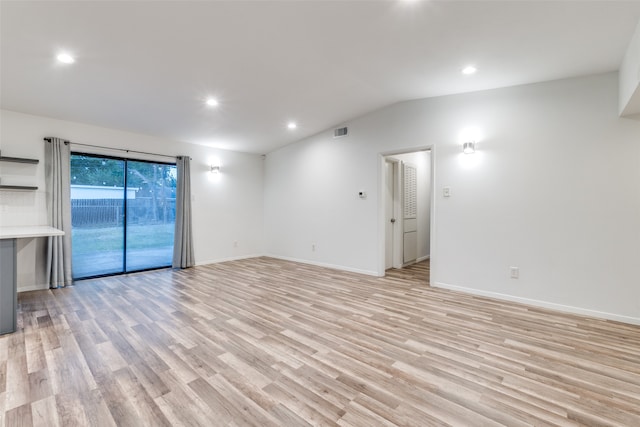 empty room with lofted ceiling and light hardwood / wood-style flooring