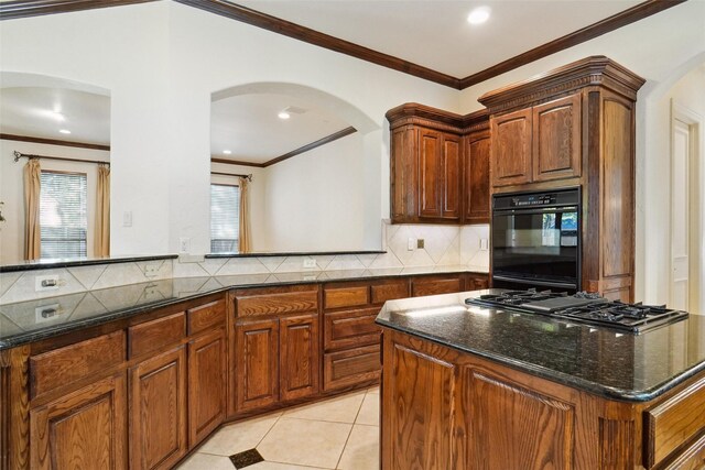 kitchen featuring dark stone countertops, light tile patterned floors, black appliances, and ornamental molding