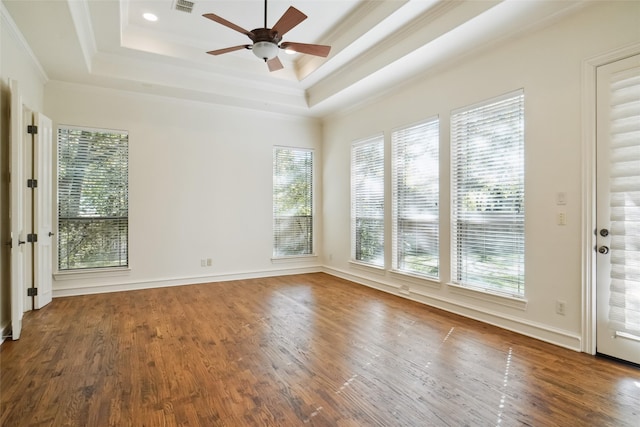 spare room with ceiling fan, wood-type flooring, ornamental molding, and a tray ceiling