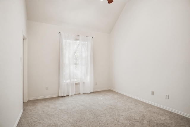 carpeted empty room featuring ceiling fan, plenty of natural light, and lofted ceiling