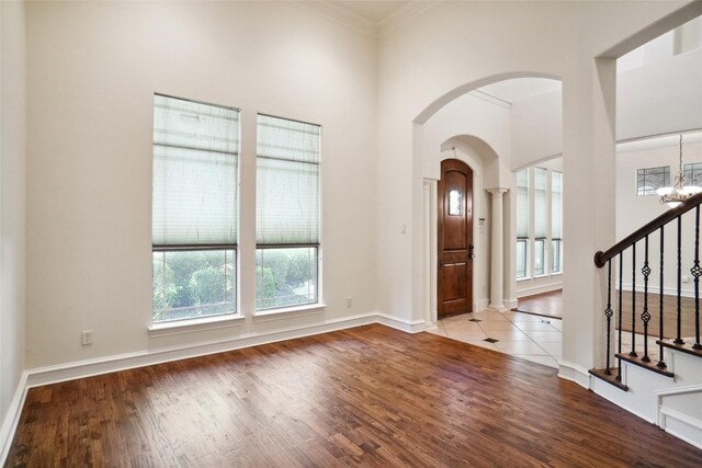 foyer entrance featuring a chandelier, light hardwood / wood-style floors, and crown molding