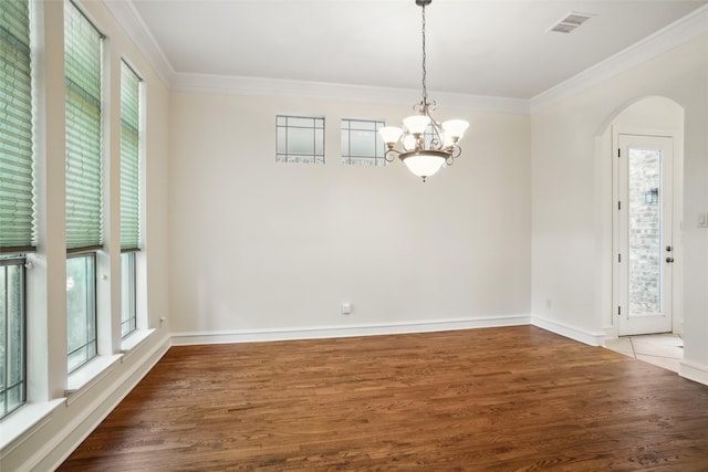 unfurnished dining area with ornamental molding, dark wood-type flooring, and an inviting chandelier