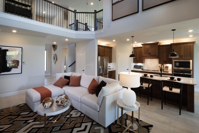 living room featuring a towering ceiling and light hardwood / wood-style flooring