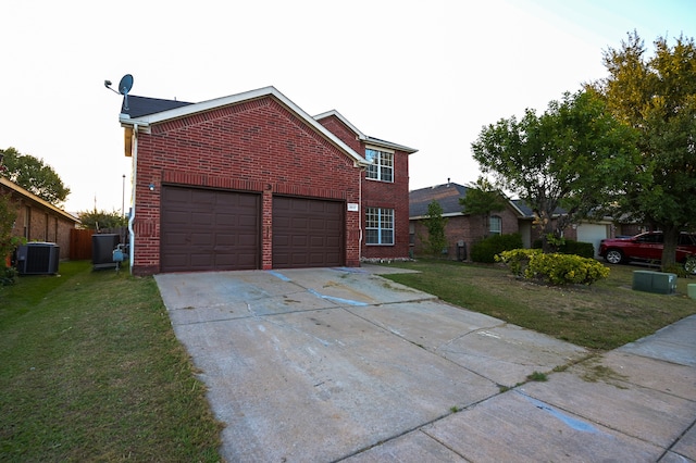 front of property featuring a front yard, cooling unit, and a garage