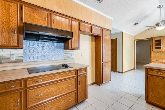 kitchen with a textured ceiling, light tile patterned floors, vaulted ceiling, black electric stovetop, and decorative backsplash