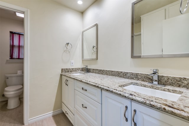 bathroom featuring hardwood / wood-style floors, vanity, and toilet