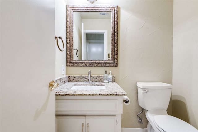 bathroom featuring toilet and vanity