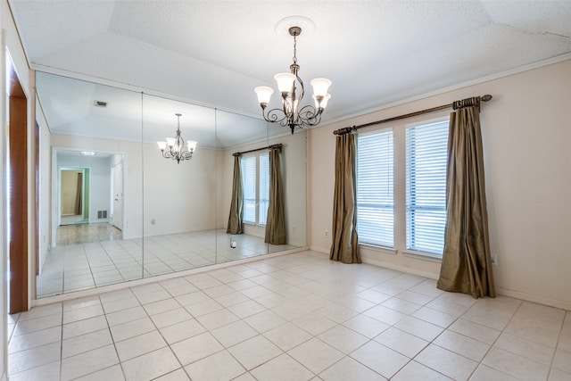 tiled spare room featuring an inviting chandelier, vaulted ceiling, crown molding, and a textured ceiling