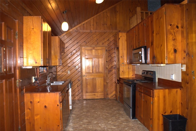 kitchen featuring lofted ceiling, sink, wood walls, wood ceiling, and appliances with stainless steel finishes