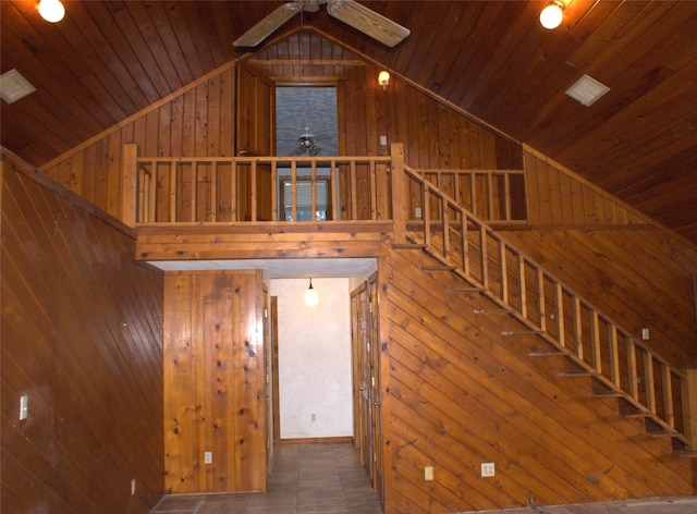 staircase featuring ceiling fan, wood walls, high vaulted ceiling, and wooden ceiling