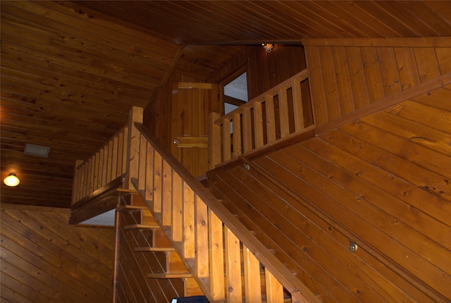 stairs featuring wooden walls, vaulted ceiling, and wood ceiling