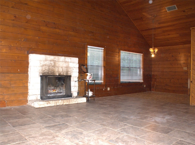 unfurnished living room with a stone fireplace, wooden walls, high vaulted ceiling, and wooden ceiling