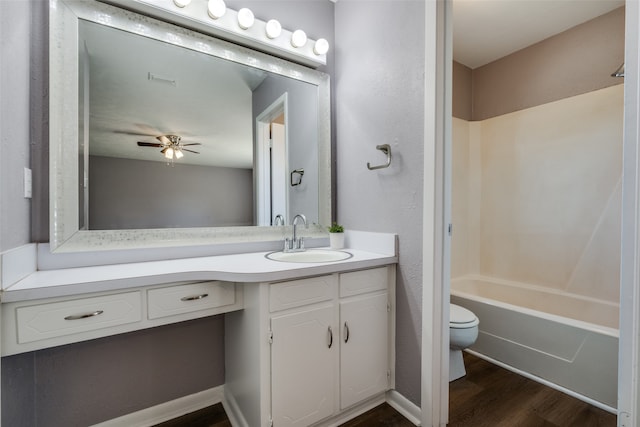 full bathroom with ceiling fan, wood-type flooring, toilet, shower / washtub combination, and vanity