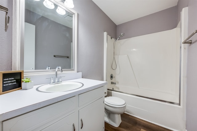 full bathroom with hardwood / wood-style floors, vanity, shower / bath combination, and toilet