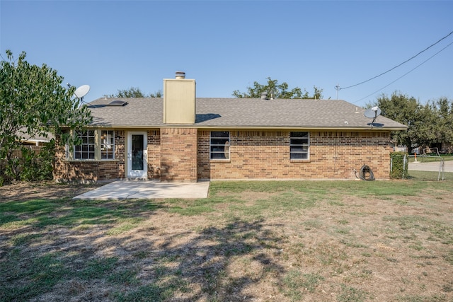 back of property featuring a lawn and a patio