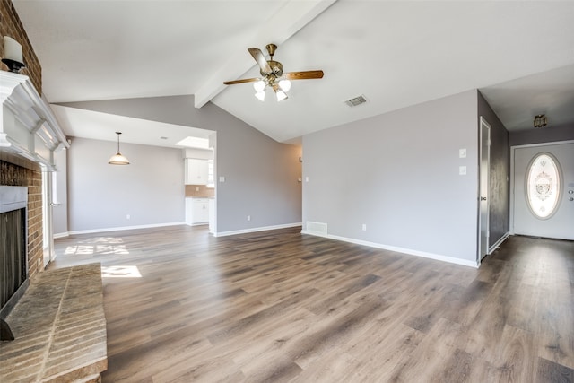 unfurnished living room with hardwood / wood-style flooring, lofted ceiling with beams, ceiling fan, and a fireplace