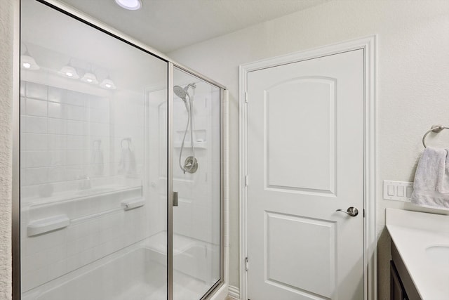 bathroom with walk in shower and vanity