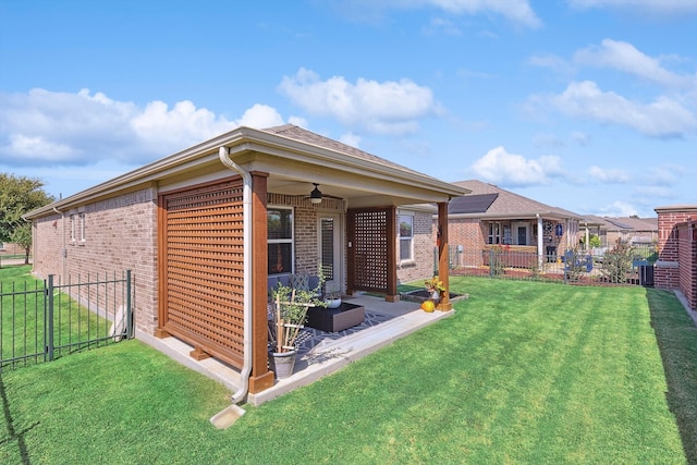 exterior space with a patio area, a lawn, cooling unit, and ceiling fan