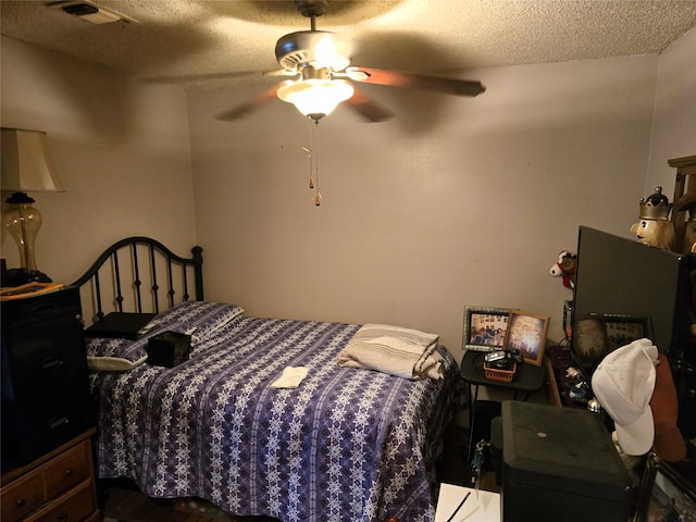 bedroom with ceiling fan and a textured ceiling