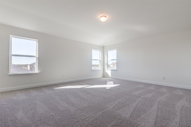 carpeted spare room featuring plenty of natural light