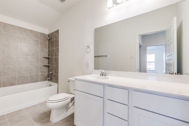 full bathroom featuring vanity, lofted ceiling, tile patterned flooring, tiled shower / bath combo, and toilet