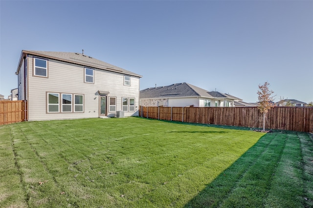 back of house featuring a yard and central air condition unit