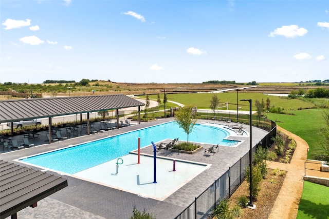 view of pool with a lawn, a rural view, and a patio