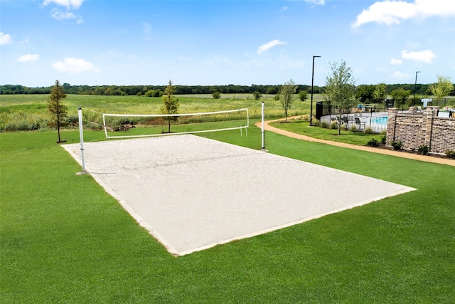 view of community featuring volleyball court, a yard, and a rural view