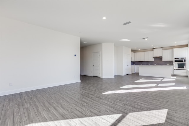 unfurnished living room featuring light hardwood / wood-style floors and sink