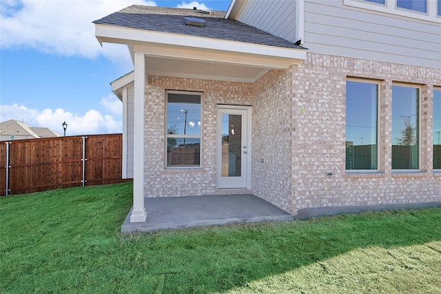 property entrance with a patio area and a yard