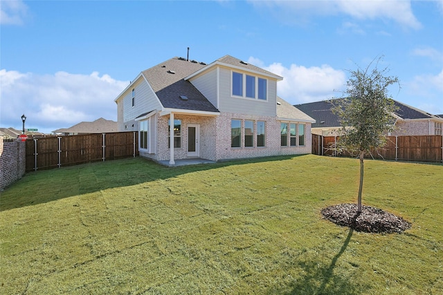 rear view of house with a lawn and a patio area