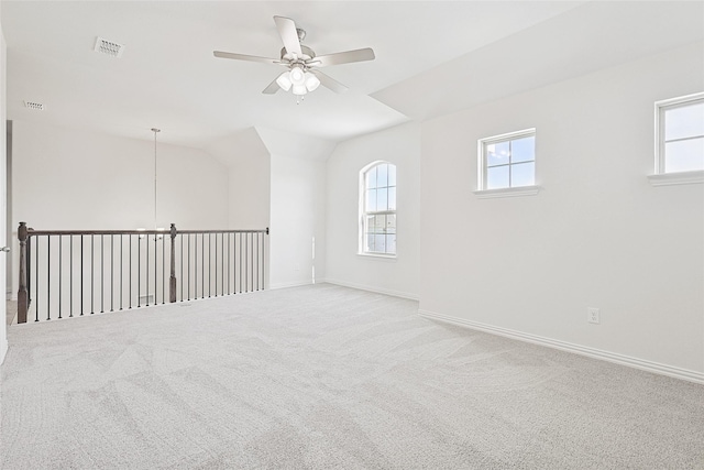 carpeted empty room featuring ceiling fan and vaulted ceiling