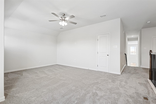 carpeted spare room with ceiling fan and vaulted ceiling