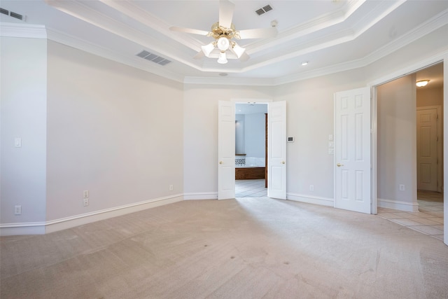 unfurnished room featuring ceiling fan, a raised ceiling, ornamental molding, and light carpet