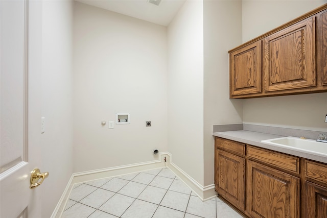 laundry room with electric dryer hookup, cabinets, sink, washer hookup, and light tile patterned flooring