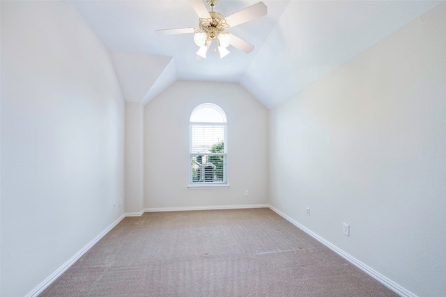 carpeted empty room featuring ceiling fan and lofted ceiling