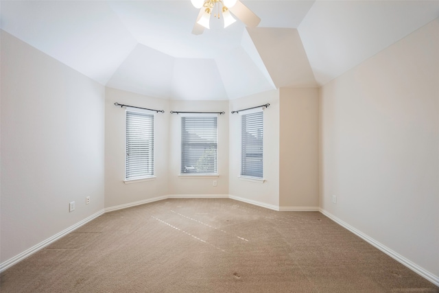 carpeted spare room featuring ceiling fan and vaulted ceiling