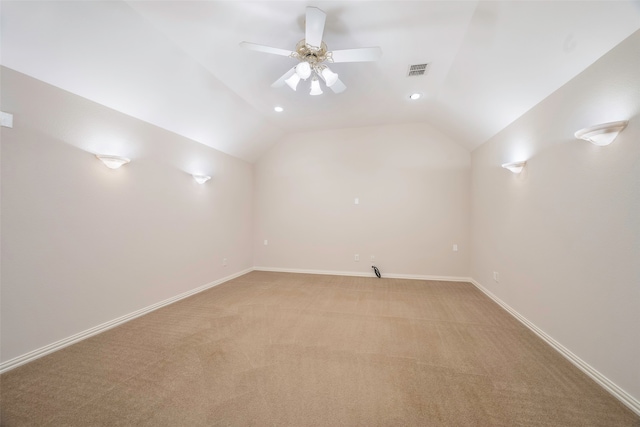 empty room with ceiling fan, light carpet, and vaulted ceiling