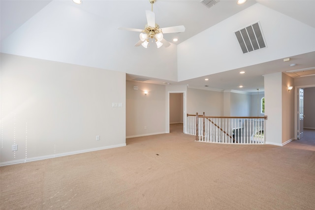 carpeted spare room with ceiling fan and a towering ceiling