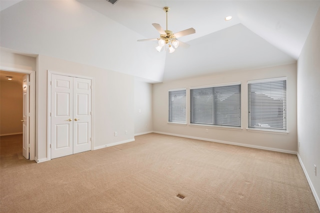 carpeted spare room featuring ceiling fan and lofted ceiling