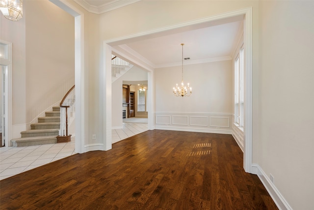 unfurnished dining area featuring ornamental molding, a notable chandelier, and light wood-type flooring