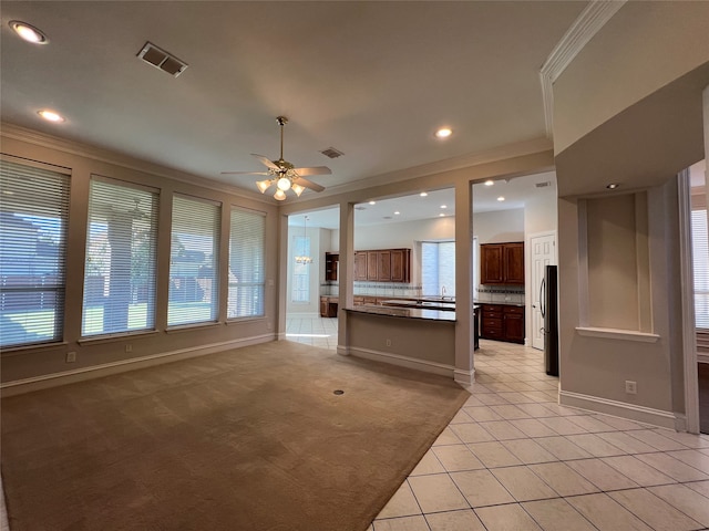 kitchen with dark stone counters, stainless steel appliances, sink, a center island, and light tile patterned flooring