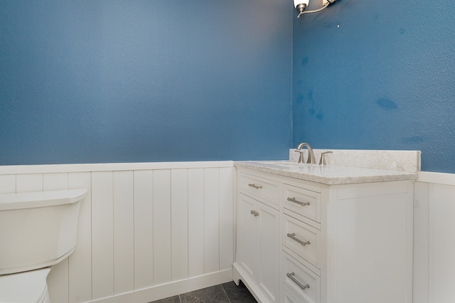 bathroom featuring vanity, tile patterned flooring, and toilet