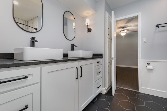 bathroom featuring ceiling fan, hardwood / wood-style flooring, vanity, and a textured ceiling