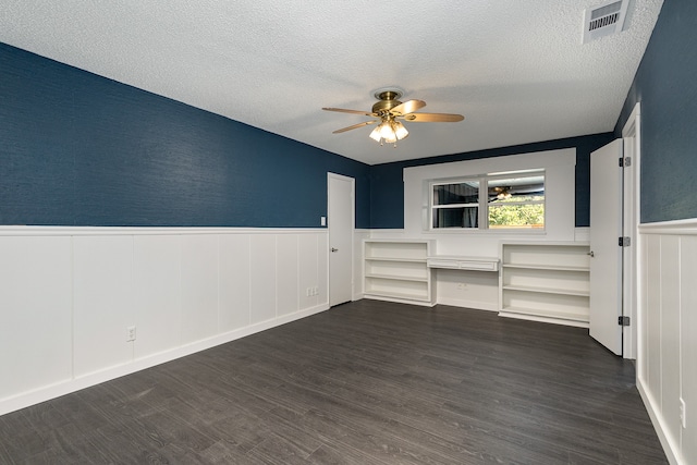 unfurnished room with ceiling fan, a textured ceiling, and dark wood-type flooring