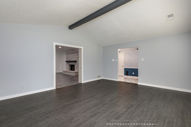 unfurnished living room featuring a textured ceiling, dark hardwood / wood-style floors, a large fireplace, and lofted ceiling with beams